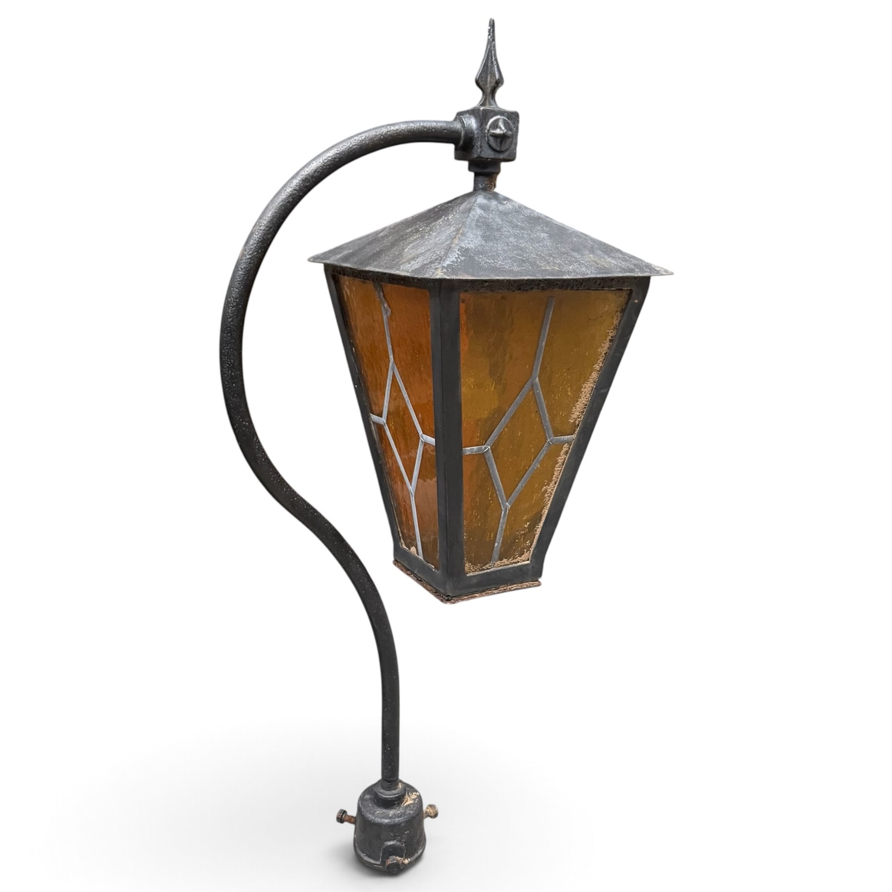 REVO Electric Co. Ltd., Tipton - early 20th century cast iron street lamp standard, the later hexagonal lantern with amber leaded glazing and pointed finial, supported on a swan-neck bracket above a ring-turned capital, tapering column and ladder rest, terminating in a moulded scrolling foliate-decorated base with lappet collar, stamped REVO

Provenance: formerly installed as street lighting in Prestwich, Greater Manchester