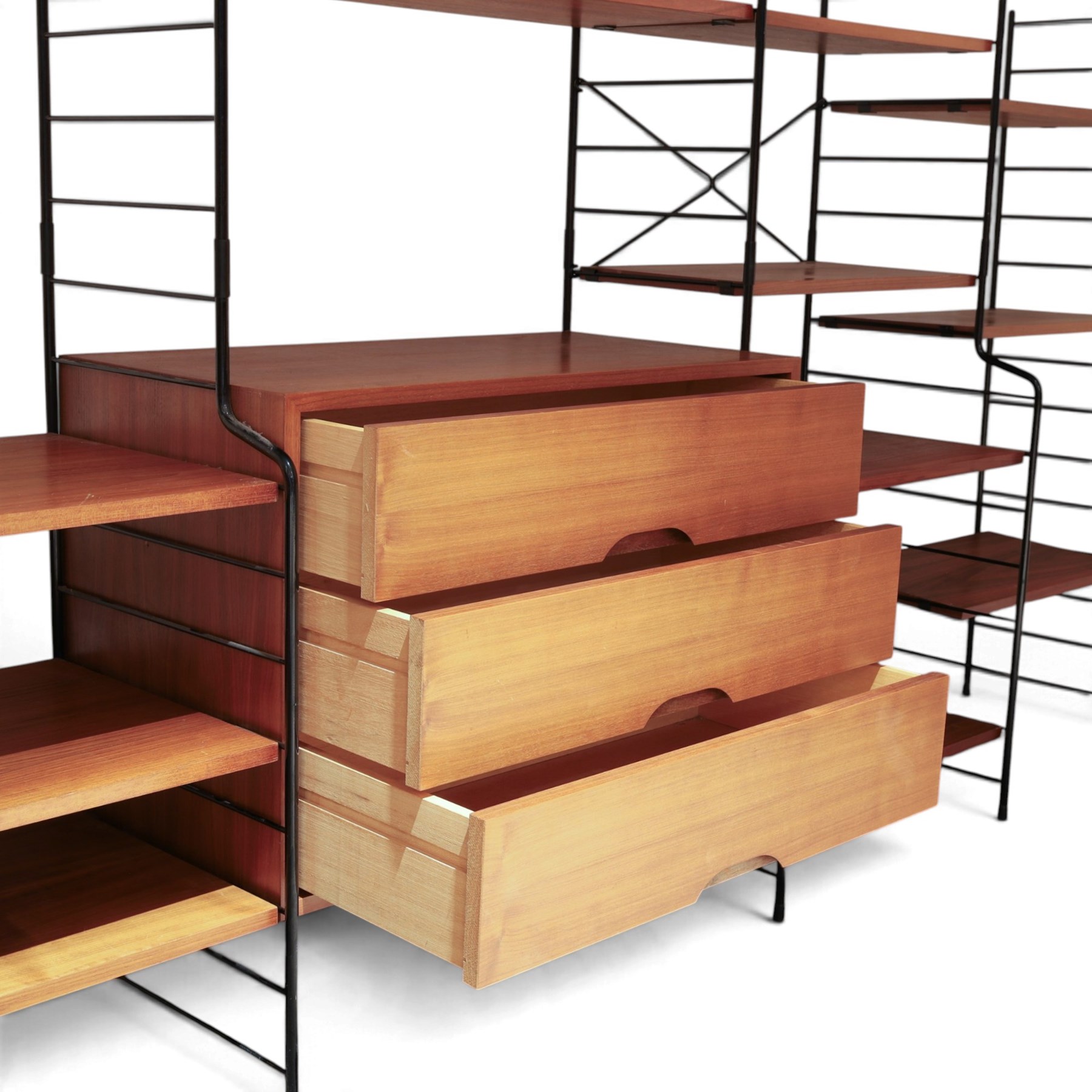 WHB - 'Ladderax' 1960s German modular shelving wall unit, comprising two teak cabinets with white doors, a further fall front teak cabinet with white front, a drawer section with three drawers with recessed handles, multiple shelving sections, raised on metal ladder frames, with further spare sections

Cabinet units: H 47cm, D 36cm, W 71cm
Fall front unit: H 40cm, D 26cm, W 71cm
Shelve widths: 50cm, 71cm 
Shelve depths: 26cm, 36cm