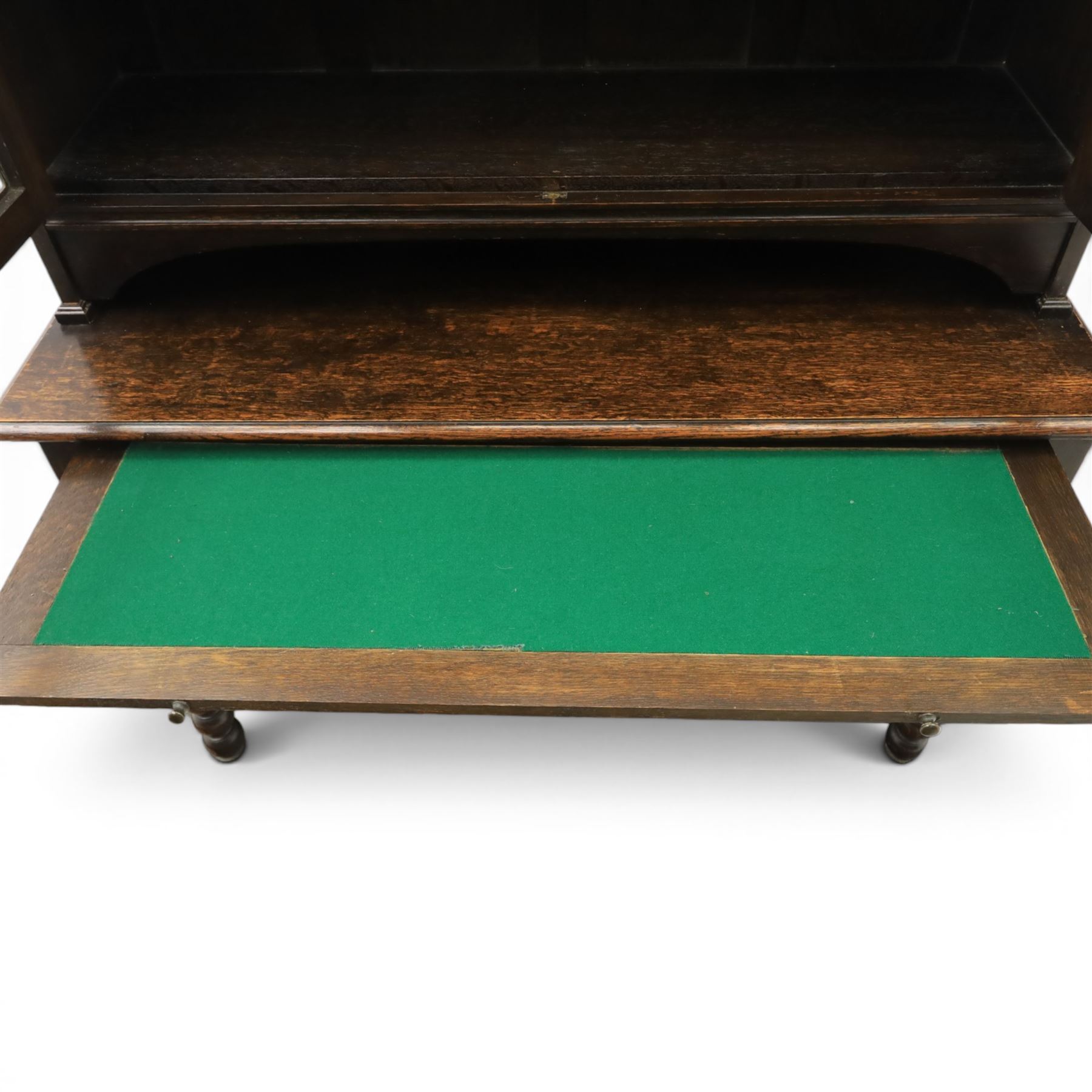 Early 20th century Jacobean Revival dark stained oak dresser, the associated upper section enclosed by twin glazed doors with shaped moulded glazing bars, over separate base fitted with two drawers, raised on bobbin turned legs