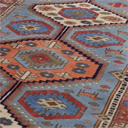 Caucasian Kazak hand-knotted rug, pale blue main field with large geometric medallions in a vertical arrangement and angular tribal motifs within a rosette and geometric border, cotton fringe end, 68x88cm