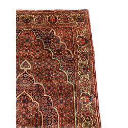 Persian Bidjar crimson ground rug, thick woollen pile, the field decorated with repeating Herati motifs within cusped outlines, the guarded border decorated with repeating flower head motifs