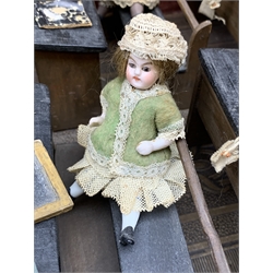 Late Victorian wooden school room setting with bisque head teacher and six German all bisque pupils each seated at a combined desk and chair with slate board, in a classroom furnished with chest of drawers, fire-surround, lectern, wall map, pictures, miniature books, school bell, chalk board on easel, wall clock etc, L70cm H28cm D28cm
