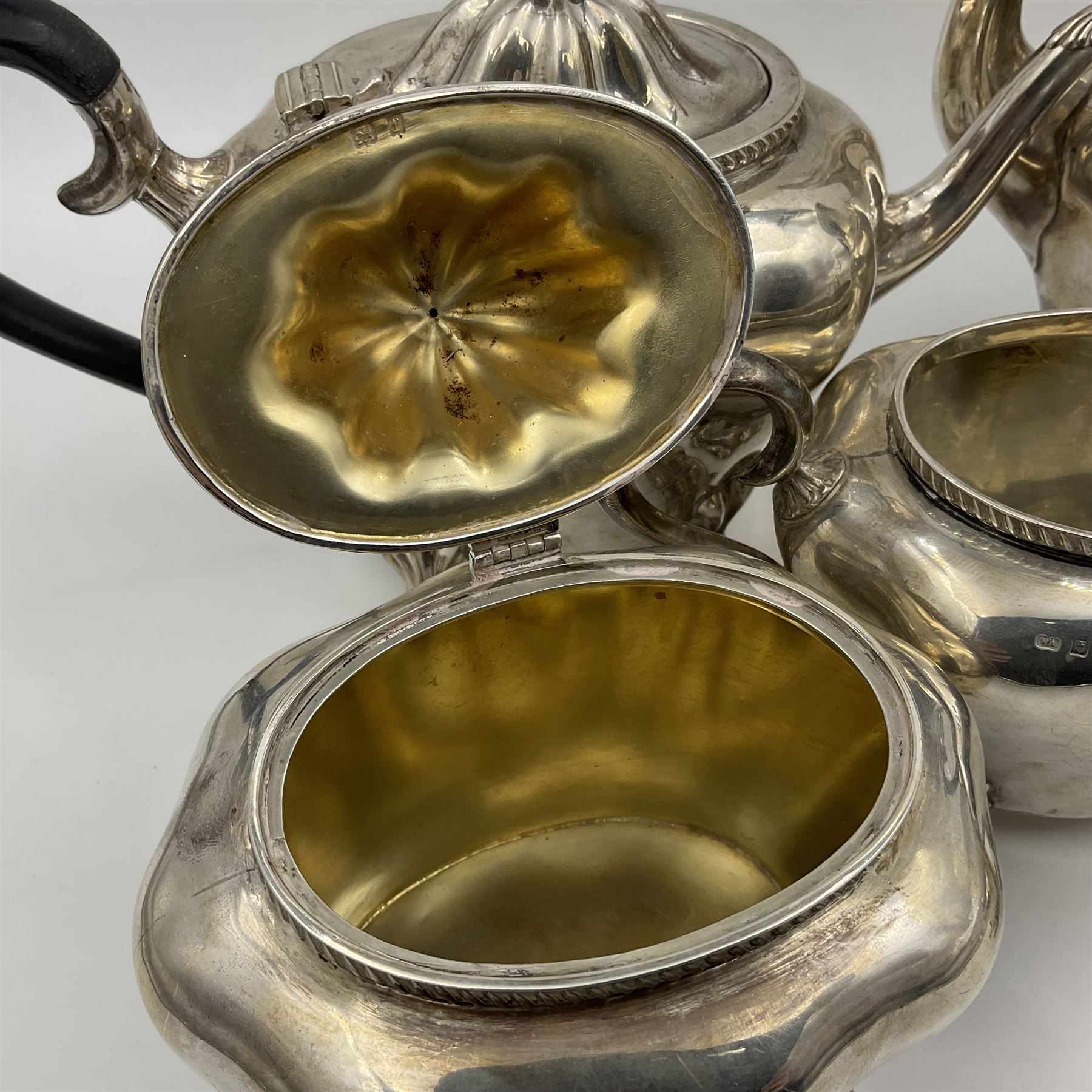 Five piece Edwardian silver tea service, comprising teapot and coffee pot, each with ebonised scroll handle, tea caddy with hinged cover, twin handled open sucrier, and milk jug, each of rounded bombe form, upon four paw feet, hallmarked William Adams Ltd, Birmingham 1904 and 1905, coffee pot H26cm
