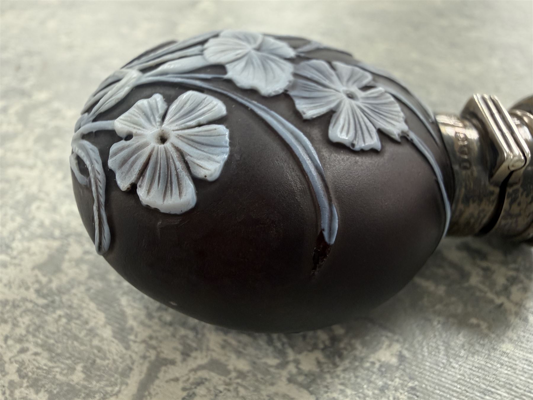 Victorian Thomas Webb silver mounted cameo glass scent bottle, hallmarked Sampson Mordan and Co, London 1884, the cameo glass body of circular form, decorated with white flowers and foliage in high relief upon a black ground, the hinged cover opening to reveal the original stopper, H6cm 
