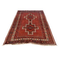 Persian Kelardasht red ground rug, the field decorated with two geometric medallions, multi-band border decorated with stylised flower heads and geometric repeating patterns