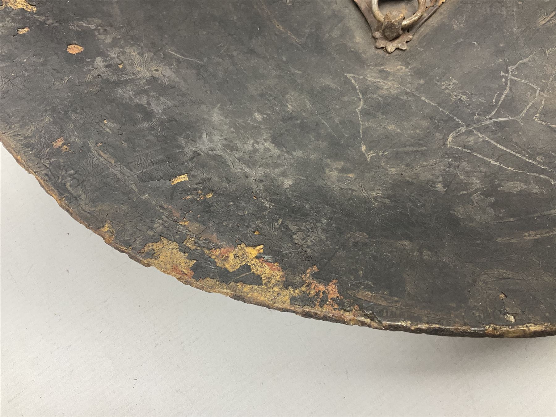 Indian black lacquered hide shield/dhal, of circular convex form fitted at its centre with four pierced iron bosses, each of hemispherical form with wide brims, the bosses corresponding on the inside with four iron rings for enarmes D53.5cm