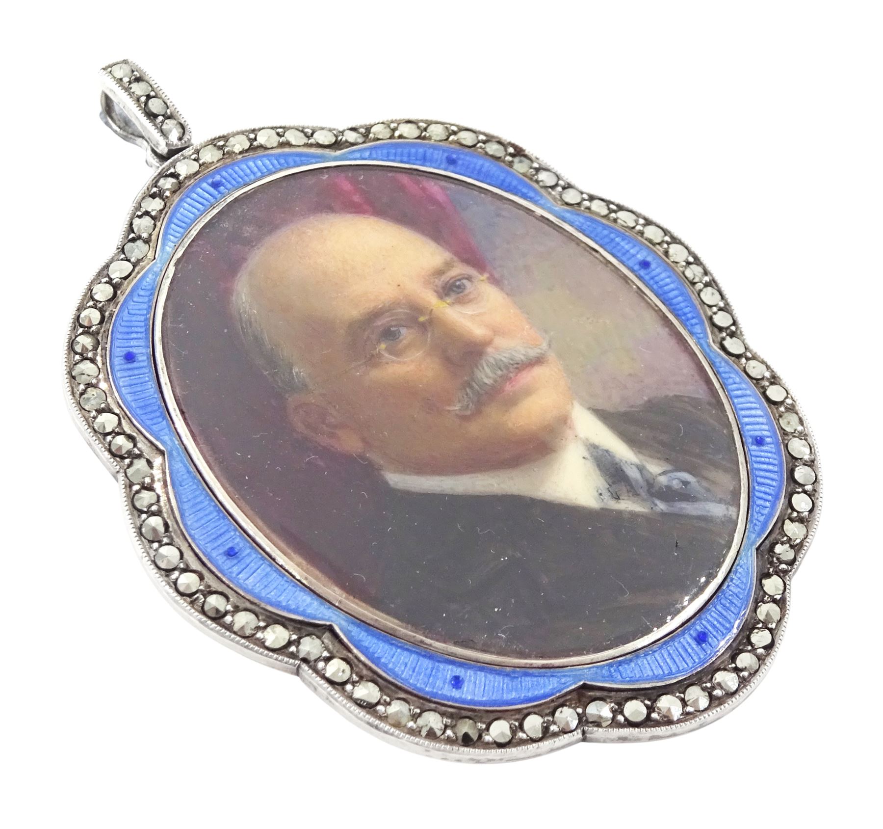 Early 20th century silver guilloche enamel portrait pendant, set with an oval miniature of a gentleman wearing a grey suit on ivory, within a blue enamel and marcasite border, the reverse set with a blue enamel panel and single split pearl, within a silver engraved border, suspended from a marcasite bail

This lot has been registered for sale under Section 10 of the APHA Ivory Act