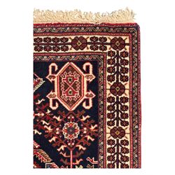 Persian Qashqai crimson ground runner, the central field decorated with three large geometric medallions with intricate angular and floral motifs, the indigo spandrels with complementary geometric designs, bordered by an ivory band with repeating floral patterns and angular vines