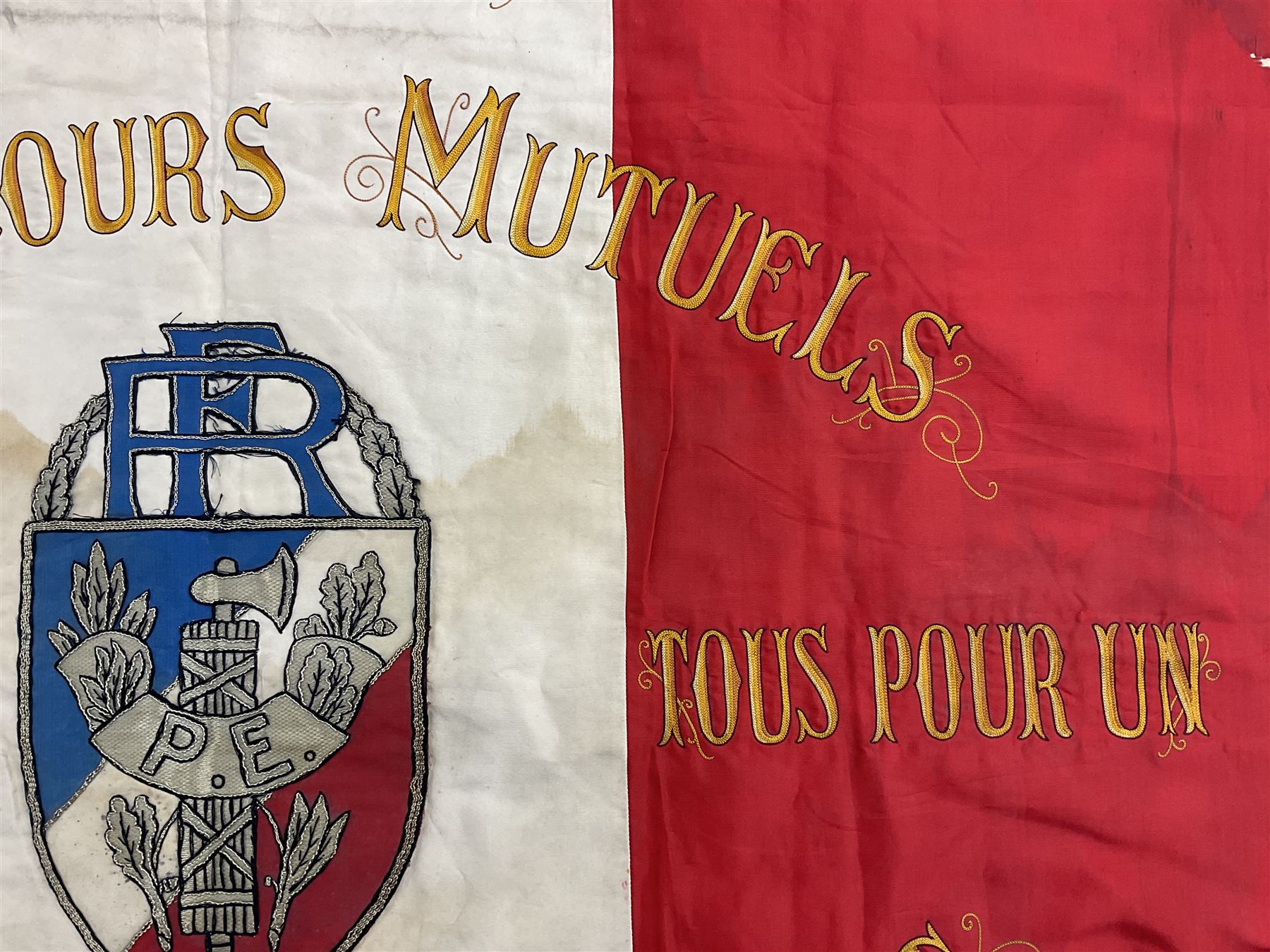 French State Police banner as the tricolor flag embroidered with coloured and metallic thread 'Societe De Secours Mutuels Un Pour Tous Tous Pour Un De La Police D'Eteat De Marseille' to one side; plain flag verso; tassels to three sides 100 x 113cm