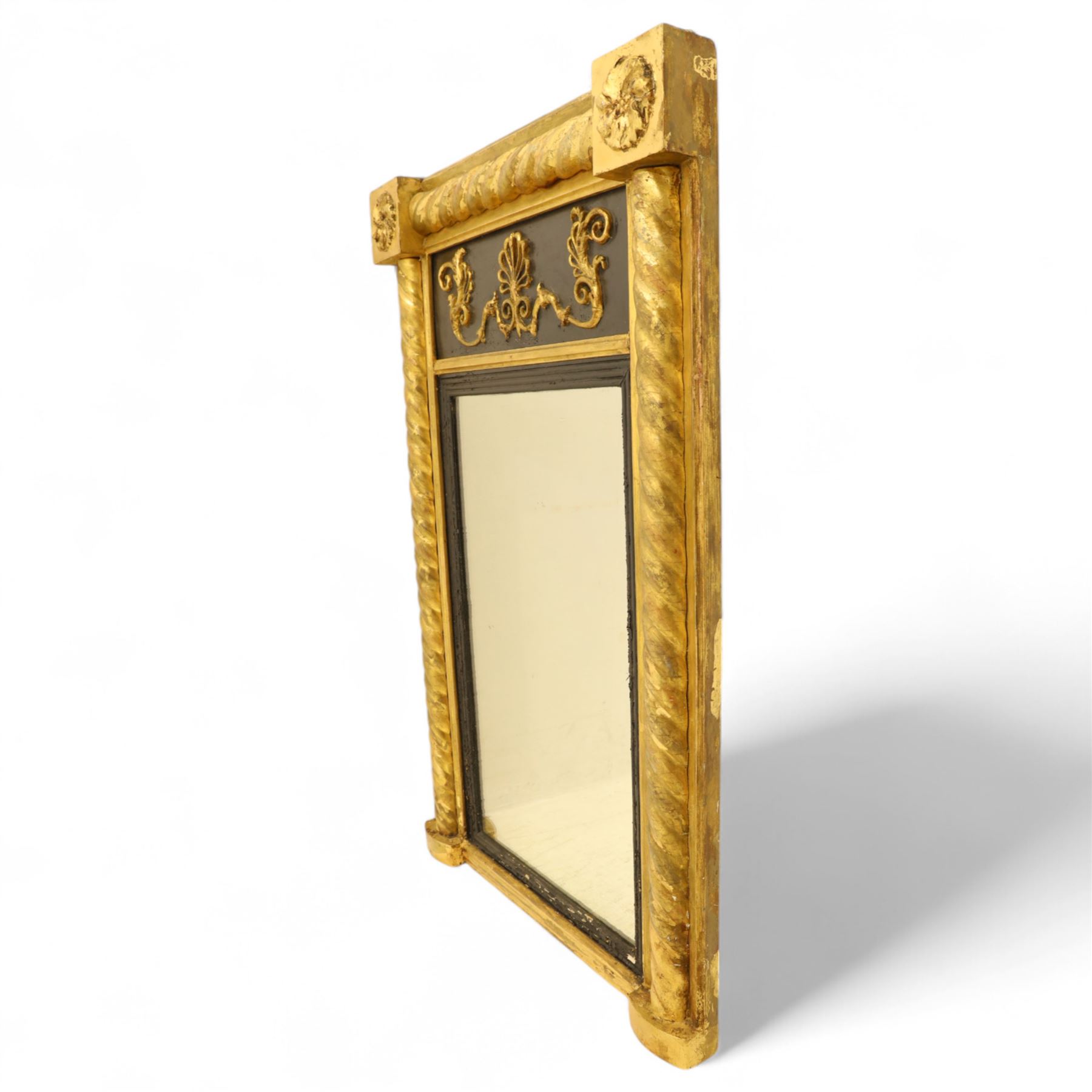 19th-century Regency-style ebonized and giltwood pier mirror, rectangular form frame with twisted rope columns on either side, ebonized frieze panel decorated with gilt applique scrollwork and central anthemion and arabesques