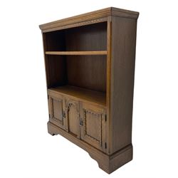 Medium oak bookcase, two shelves over two cupboards and central arch decoration