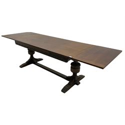 20th century oak drawer leaf extending dining table, two foliage carved baluster supports on sledge feet joined by floor stretcher 