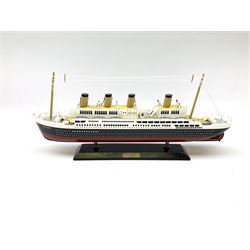 Wooden model of RMS Titanic, on a fixed black stand bearing plaque inscribed 'Titanic 1912', L54cm, H22cm, together with model of a sloop, gaff rigged on stand bearing plaque inscribed 'Sloop' L32cm, H42cm; and model of a fishing trawler on a stand bearing plaque inscribed 'Chalutier' L35cm, H28cm (3)