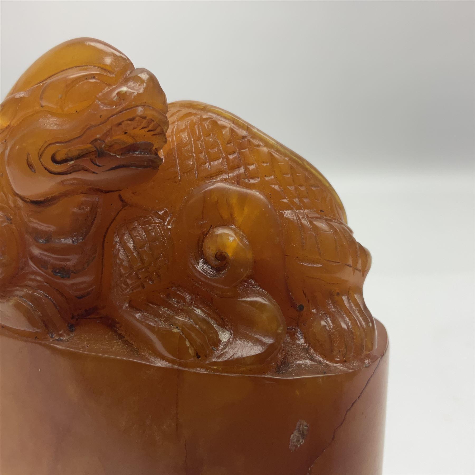 Chinese amber soapstone seal of oval form,  carved temple dog finial, inscription on the back and base, H12cm
