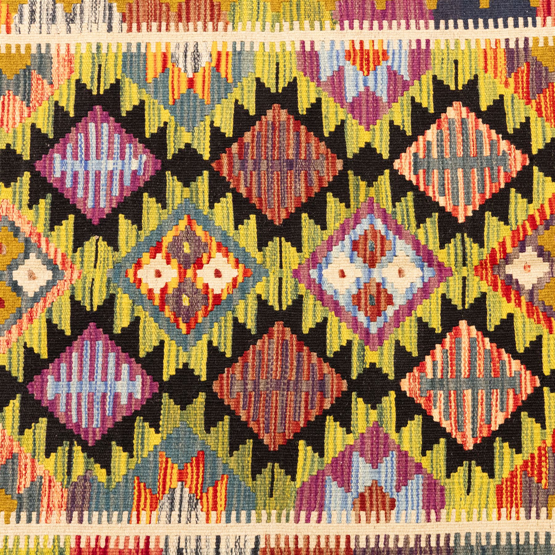 Afghan Maimana flatweave kilim, central field features large bold nested diamond motifs and stylized geometric lozenge patterns on olive purple, blue, and green tone ground, border stripe in mustard ground, and fringe