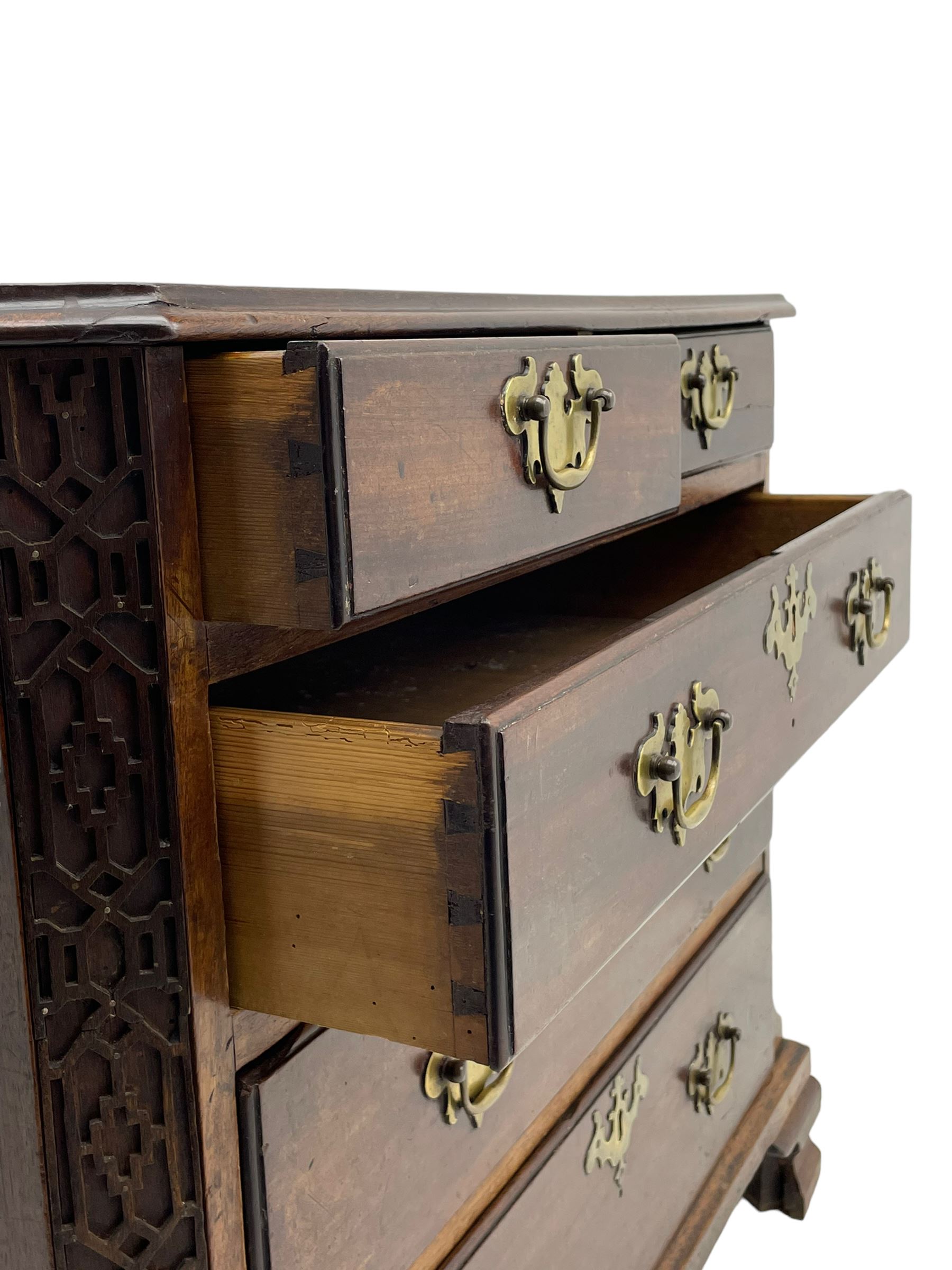 George III Chippendale design mahogany chest, moulded rectangular top with canted corners, wide canted uprights with blind fretwork decoration, two short and three long with moulded fronts, shaped brass handle plates, on ogee bracket feet 