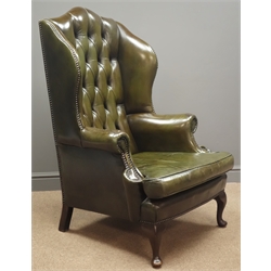  Georgian style wingback armchair, upholstered in buttoned green leather, with studded detailing, front cabriole supports and two square supports to the rear, W77cm, H117cm, D70cm  