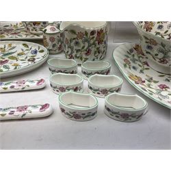 Minton Haddon Hall pattern tea and dinner wares, including basket dish, two covered tureens, six dinner plates, eight dessert plates, twelve tea plates, six soup bowls, six cereal bowls, teapot, coffee pot, milk jug, covered sucrier twelve tea cups and saucers, six mugs, footed bon bon dish, pair of candlestick holders, cake knife and slice etc (81)