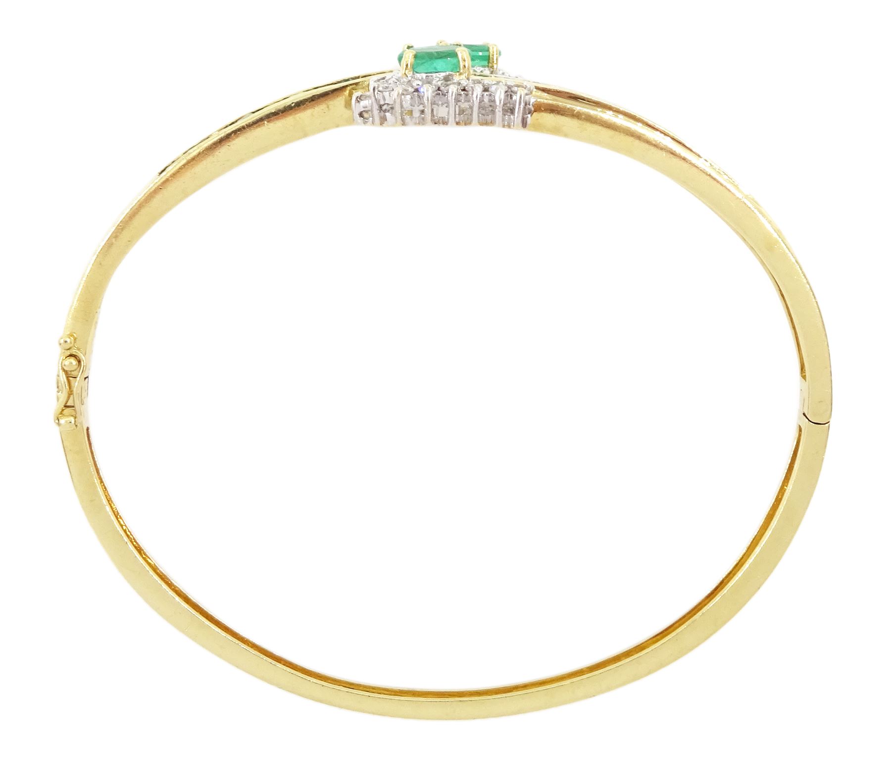 14ct gold emerald and diamond crossover bangle, two oval cut emeralds with round brilliant cut diamond surround, with channel set calibre cut emerald shoulders, stamped 585