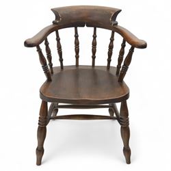 Early 20th century smokers bow armchair, shaped and curved top rail over turned spindles and open arms with rounded terminals, shaped elm seat on turned supports