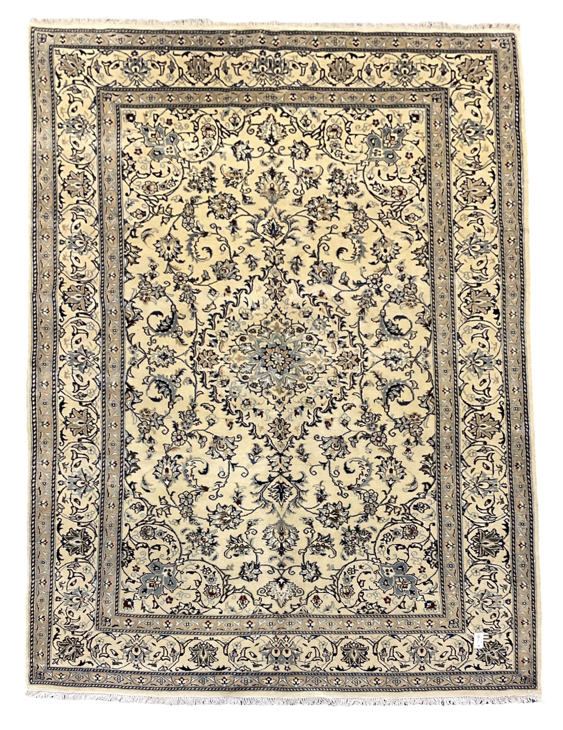 Central Persian Nain rug, wool with silk inlay, ivory ground decorated with scrolling and interlaced branch with stylised plant motifs, central floral medallion, triple band border with repeating design