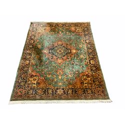 Persian style green ground rug carpet, large central medallion surround by geometric design and stylised flower heads, four band border 