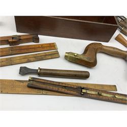 Early 20th century mahogany two division carrying box or tray, containing various tools, including fruitwood and brass brace, boxwood rulers and foot measures, spoke shaves, milliners stamps, etc. 