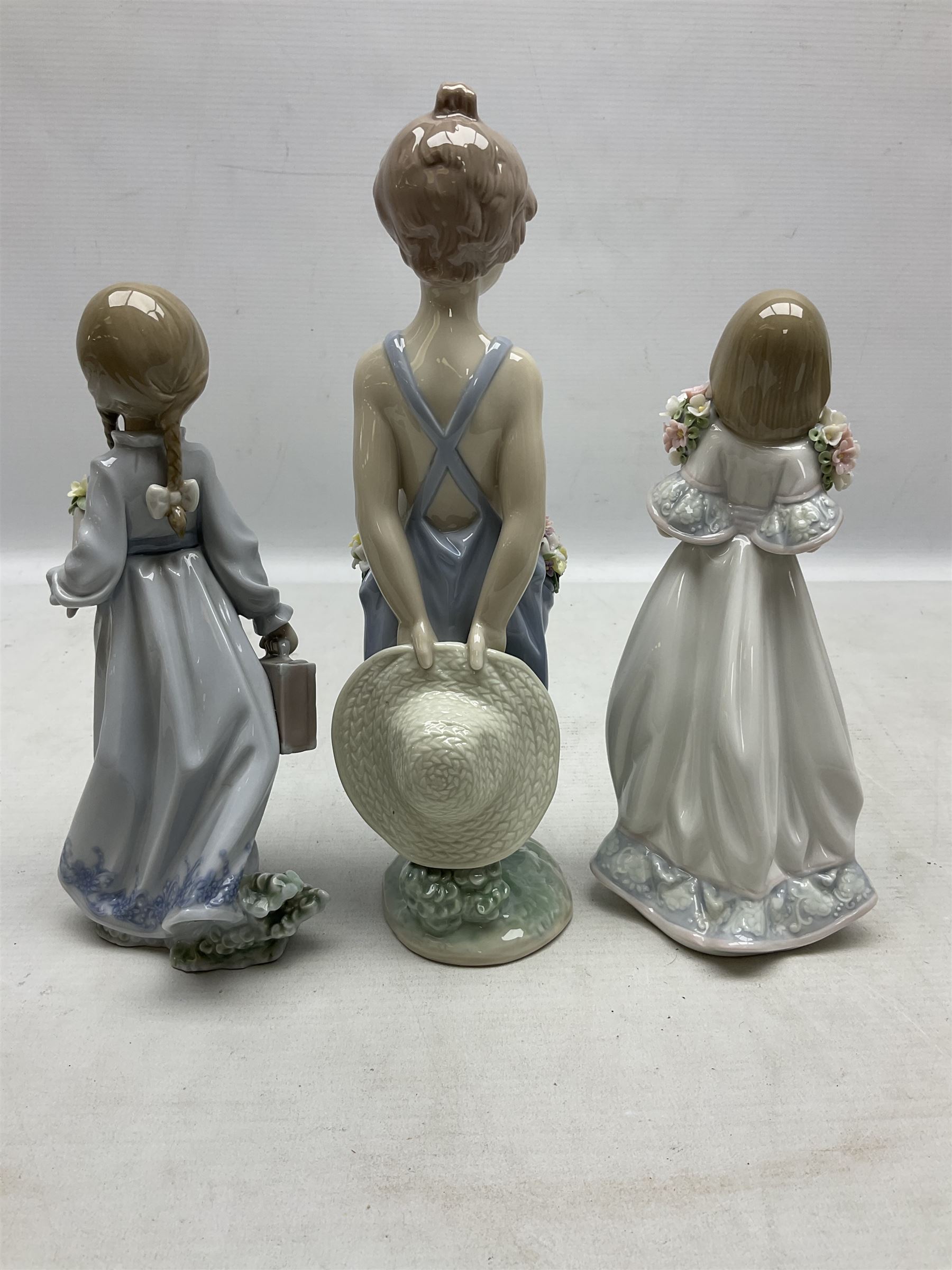 Three Lladro figures comprising, Pocket Full of Wishes no 7650, School Days no 7604 and Spring Bouquets no 7603, all with original boxes, largest example H26cm  