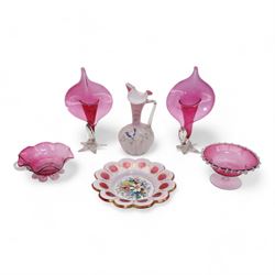 Early 20th century Bohemian cranberry glass flower form plate, overlaid with opaque and hand painted and gilded with a floral bouquet, D19.5cm, pair of cranberry glass pulpit vases, satin glass ewer and two further pieces of cranberry glass (6)