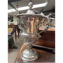 George III silver two handled campana shape cup and cover with pineapple lift, the body with cartouche surrounded by flowers above leaves and scrolls on a pedestal foot with acanthus leaf decoration H29cm London 1764, makers marks rubbed