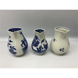 Four 18th century Worcester porcelain jugs, comprising three sparrow beak examples, the first example decorated in the Bat or Vase pattern, circa 1780, with underglaze blue disguised numeral mark beneath, the second in the Three Flowers and Butterfly pattern, the third decorated with floral and fruit spray and sprigs, and a floral moulded example decorated in the Chrysanthemum pattern, circa 1765, together with a Caughley example decorated in the Fisherman or Pleasure Boat pattern, circa 1760, with underglaze blue crescent mark beneath, and a late 18th century blue and white cabbage moulded jug, decorated in the Lady with parasol pattern, H14.5cm, (6)




