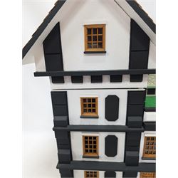 1:24 scale four-storey tudor-style dolls house, with black and white exterior, balcony garden, glazed panelled windows and wooden shingle roof, with decorated interior and wired fireplaces and lighting, H65cm, W58cm, D31cm, 