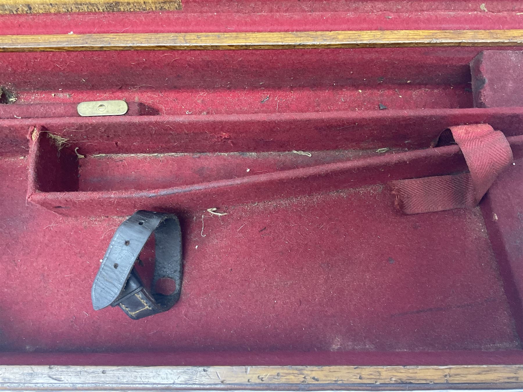 Leather shotgun case, the red baize lined interior with the trade labels of Westley Richards & Co., London, a brass plaque inscribed 'T Nevin, Mirfield, Yorkshire' to cover, with key, case to fit barrel 76cm (30 inches)  
