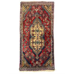 Antique Afghan indigo ground rug, the central pole medallion within a crimson field decorated by foliate motifs (167cm x 84cm); and a Persian crimson ground rug, floral medallion within a lozenge field, guarded border decorated with repeating stylised plant motifs (123cm x 73cm) (2)