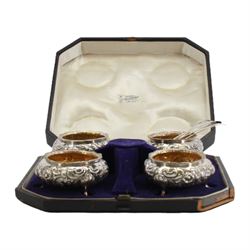 Cased set of four Victorian silver open salts, each of cauldron form with embossed foliate decoration, gadrooned rim and gilt interior, upon three hoof feet, hallmarked William Hunter, London 1844, H4cm, together with four earlier Georgian salt spoons, hallmarked London 1800, makers marks worn and indistinct, contained within a fitted case with velvet and silk lined interior
