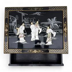 20th century Japanese Shibayama style black lacquered cabinet, rectangular form decorated with mother-of-pearl and hardstone figural inlay, the top with four standing figures, single frieze drawer above two cupboard doors, gilt painted borders and landscape