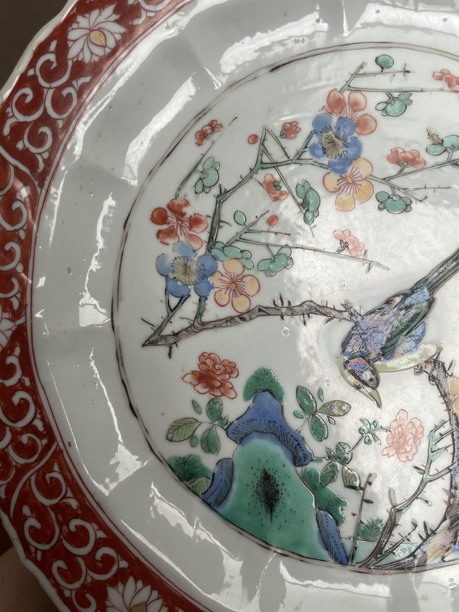 Chinese Kangxi famille verte plate, decorated with a bird perched upon a blossoming branch, within an iron red foliate border, D22cm