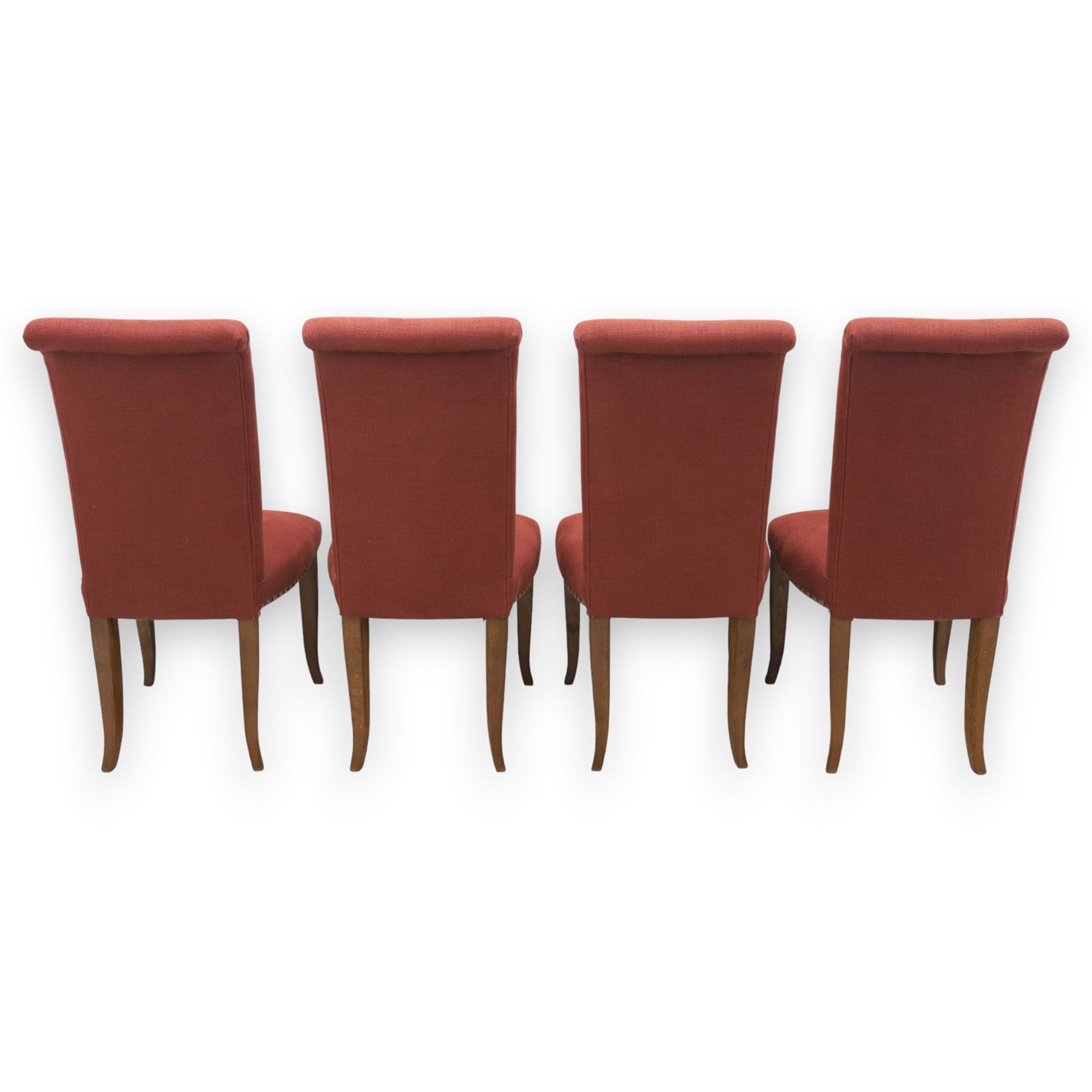 Contemporary circular painted dining table and four red upholstered chairs, table with distressed finish in black with quatriform base and bronze painted edges, chairs with 
