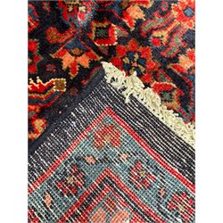 Persian indigo ground rug, the field decorated all over with floral Heratti motifs, crimson border with trailing stylised flower heads, within guard stripes