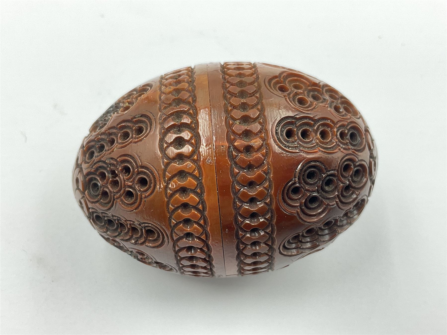 Three 19th century coquilla nut pomanders or flea catchers, two of egg shaped form and the third of barrel from with carved and pierced decoration and screw threaded join, largest H8cm