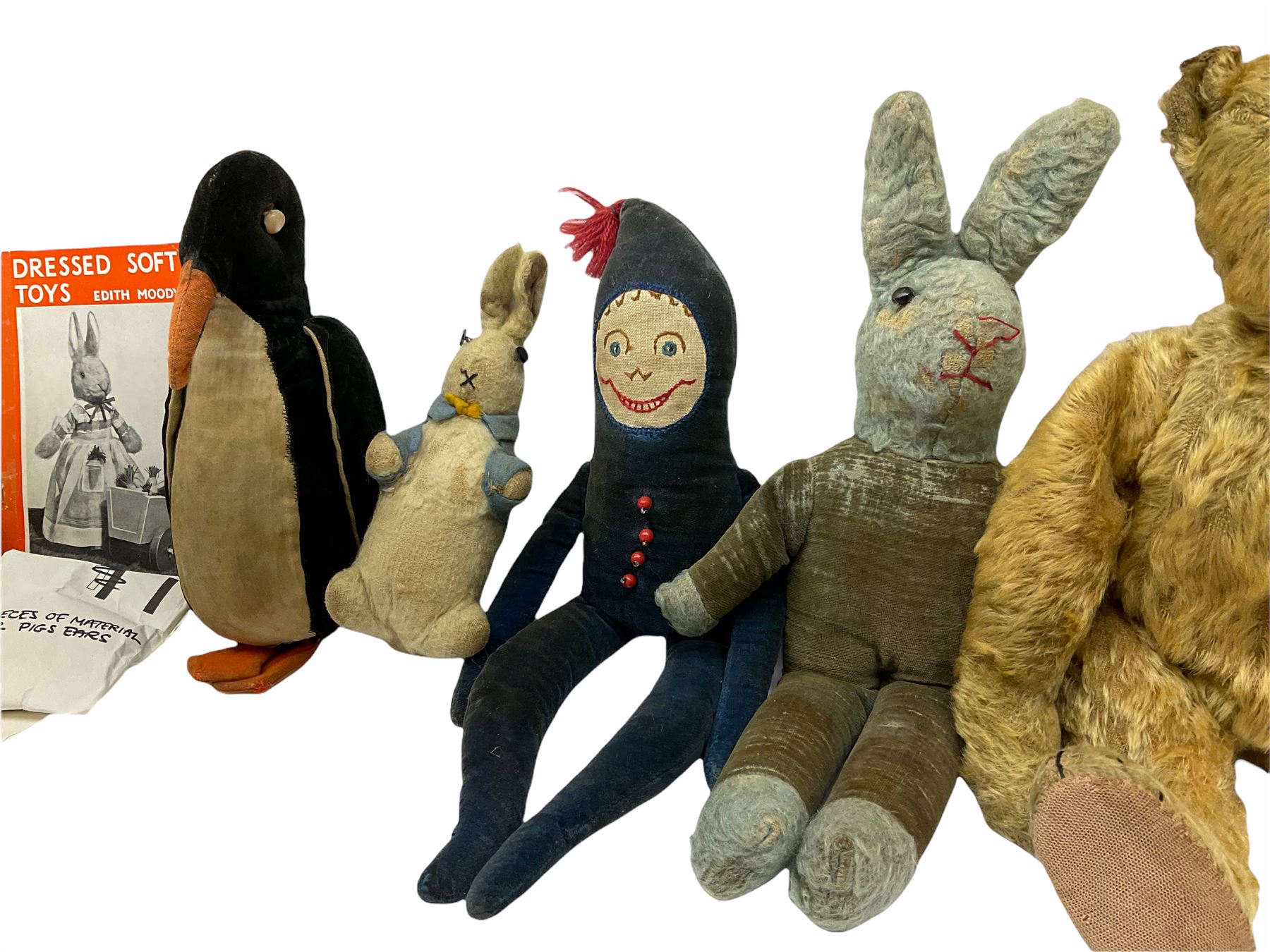 1950's teddy bear with jointed limbs, revolving head, wood filled body, stitched nose and mouth, applied glass eyes and foot pads, together with a quantity of handmade soft toy rabbits and penguins. 