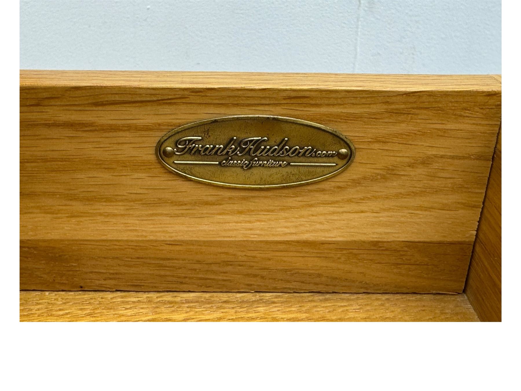 Frank Hudson - contemporary pair of light oak bedside cabinets, each with moulded rectangular top over single drawer above cupboard door with arched panel, on a moulded plinth base with bracket feet