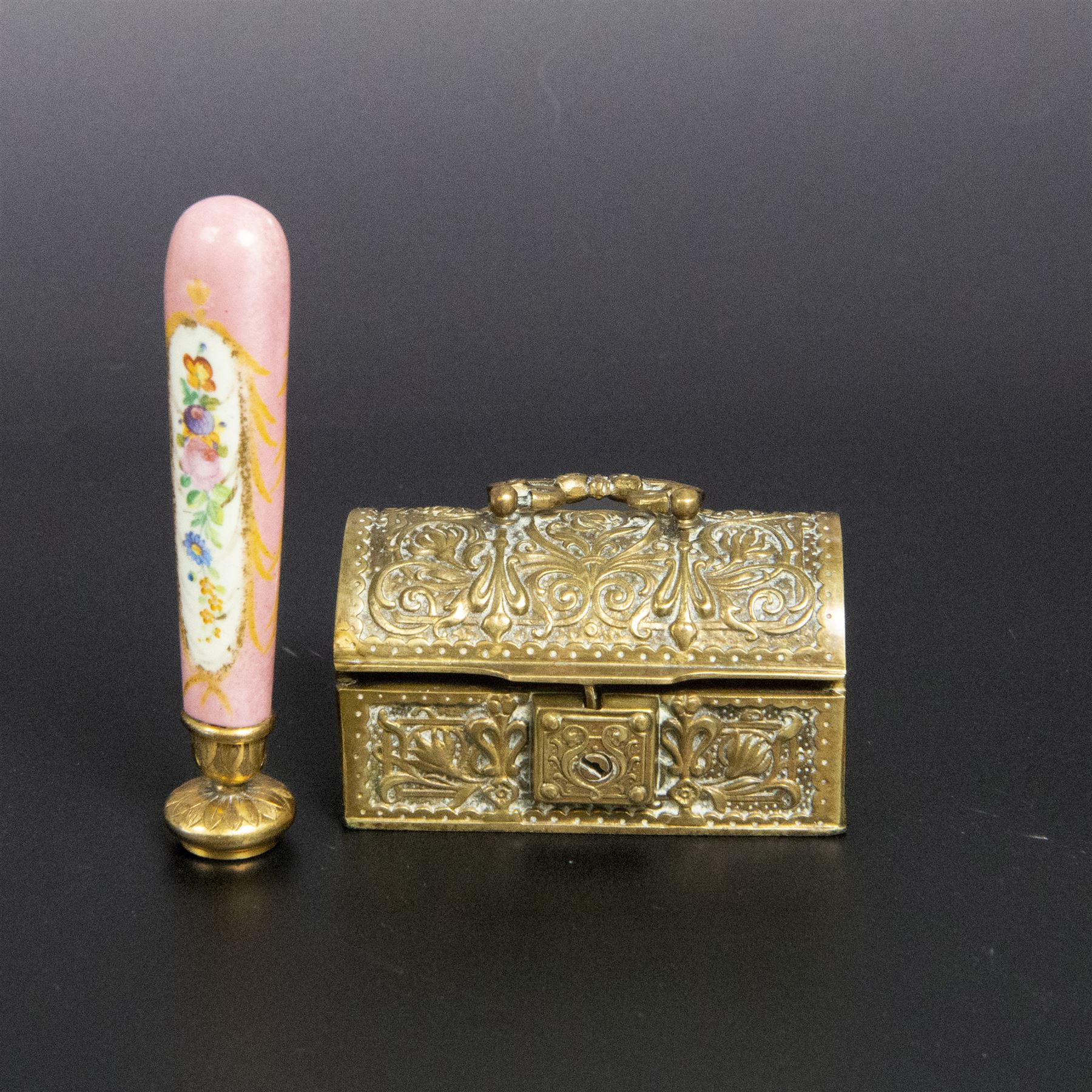 Gilt bronze mounted black glass seal, contained within a brass casket, with velvet interior and inner label reading 'C. F. Schmedding Augsburg', together with a porcelain handled seal decorated with floral sprays on a pink ground