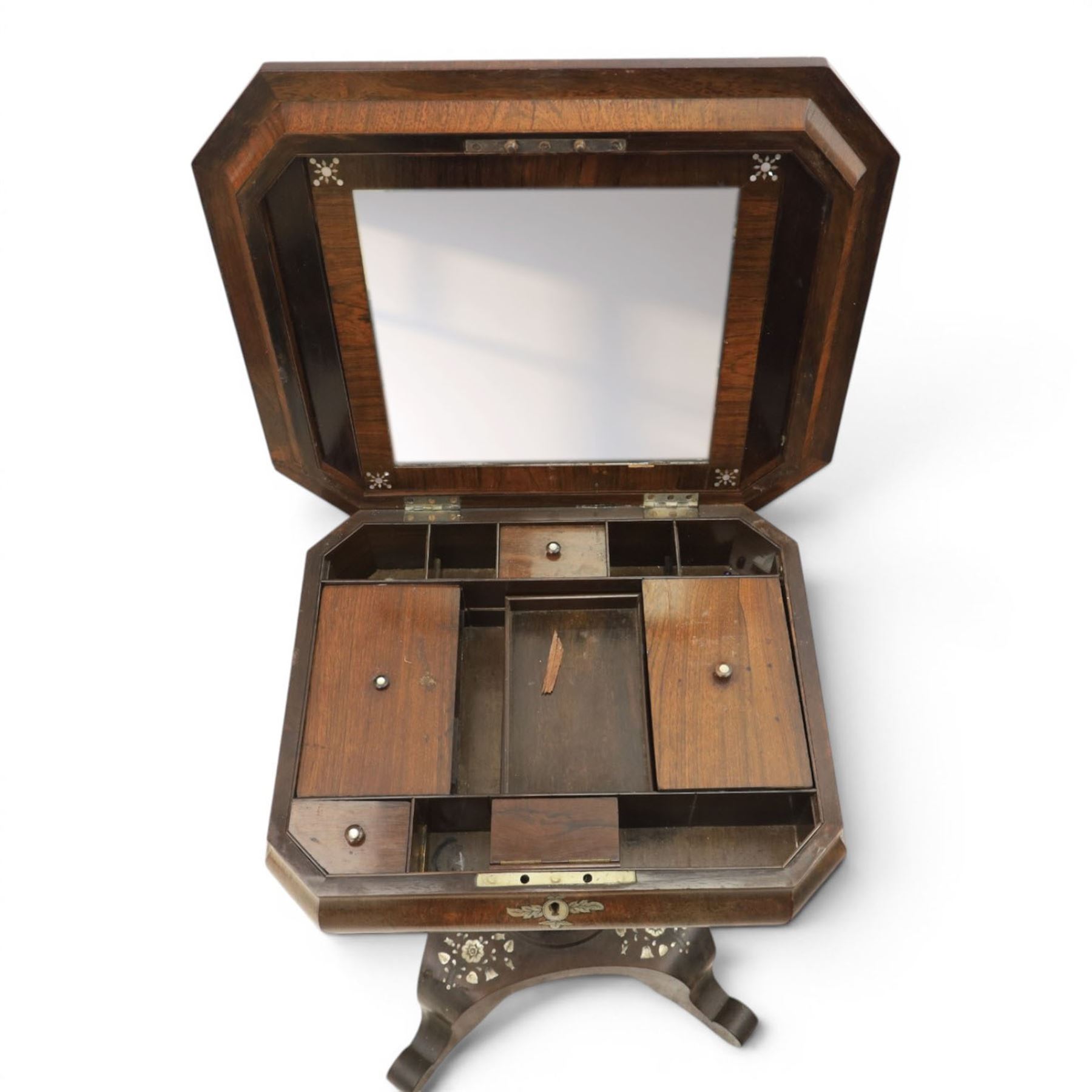 Victorian mahogany and mother-of-pearl inlaid work table, the octagonal hinged top enclosing a mirror and fitted compartmented interior, raised on a carved pedestal and quatriform platform base with scrolled feet