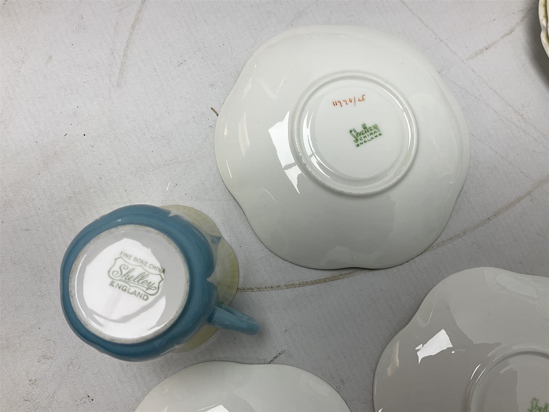 Shelley Dainty pattern tea wares, of lobed form with blue star decoration on merging white and yellow ground, comprising five teacups, five saucers, six tea plates, milk jug and cake plate, all with printed green mark beneath, some with painted pattern no 11770