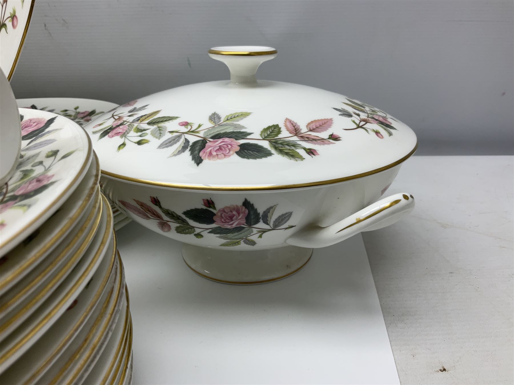 Wedgwood Hathaway Rose pattern tea and dinner wares, comprising twelve saucers, sixteen teacups, twenty tea plates, jug, sucrier, thirteen shallow bowls, sauce boat and saucer, two lidded tureens, larger jug, ten dinner plates, nine smaller plates and two large oval serving dishes