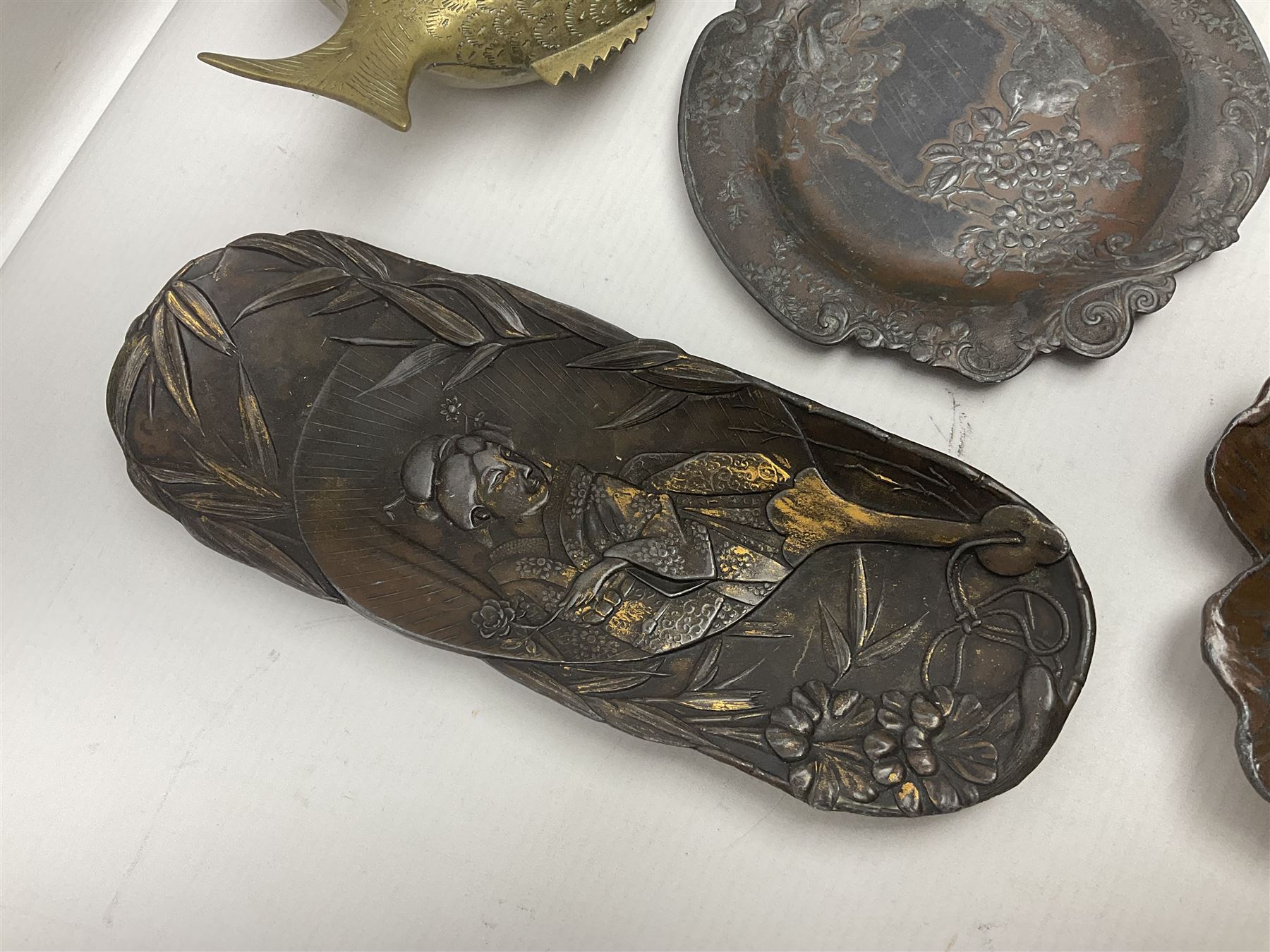 Brass sunfish ashtray, Chinese silver plated trinket box with mirror, bronzed matchbox cover and a collection of other Oriental bronzed embossed metal trays