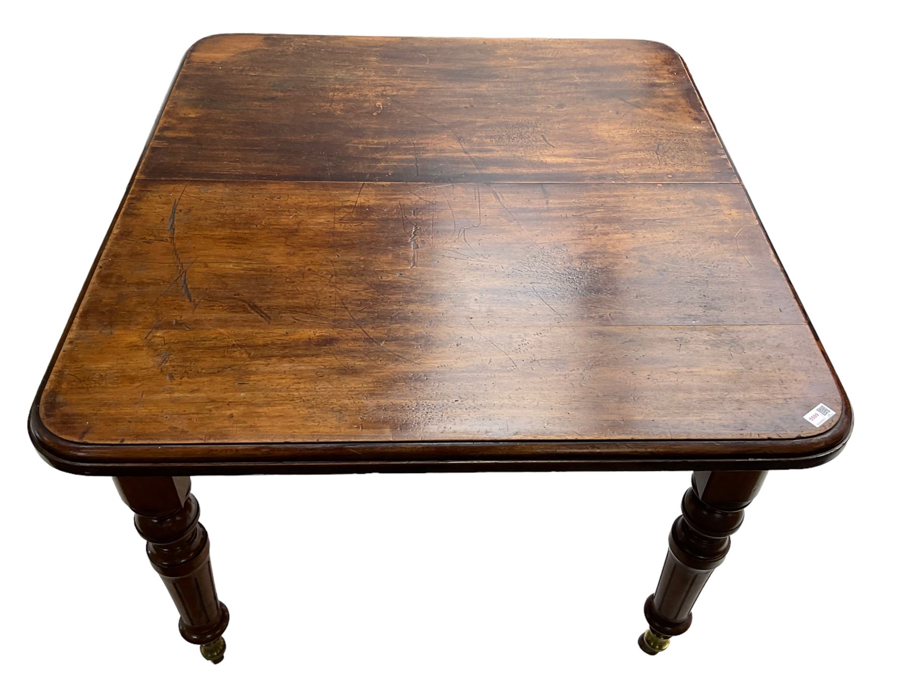 19th century mahogany extending dining table, moulded rectangular top with rounded corners, on turned and fluted supports with brass and ceramic castors