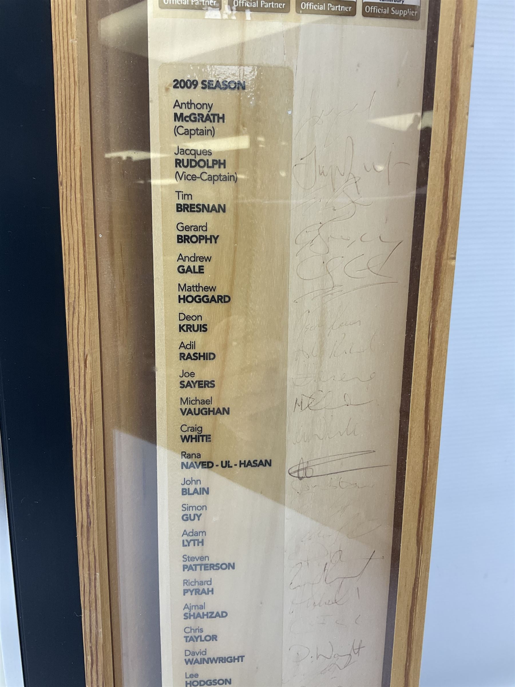 Two signed Yorkshire County cricket bats, bearing signatures including Anthony McGrath, Jacques Rudolph, Michael Vaughn and Matthew Hoggard, etc, both within glazed presentation boxes, box H86.5cm, together with a framed Darren Gough signed presentation print by Gary Keane