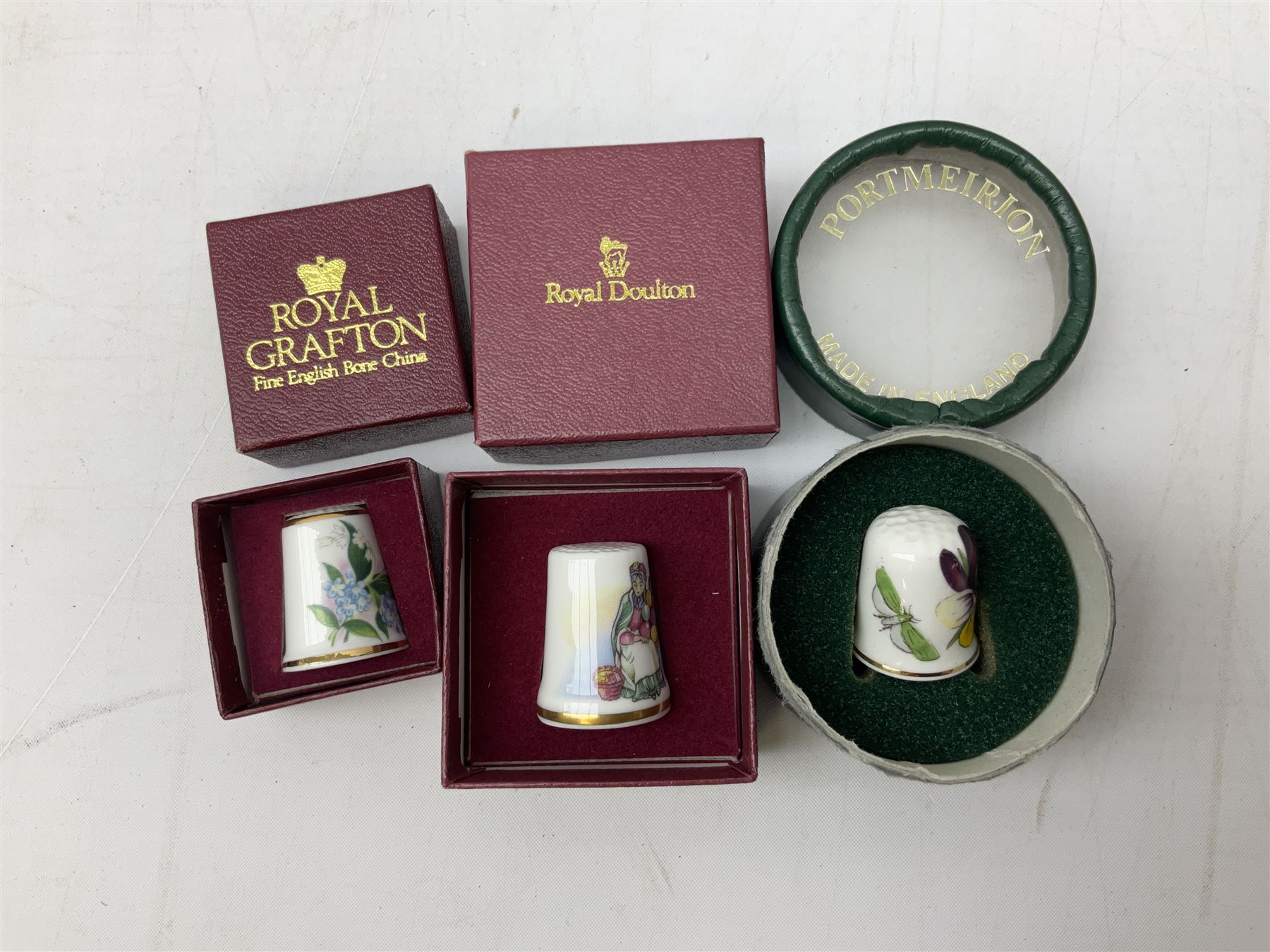 Quantity of thimbles to include twelve Irish Dresden lace examples, Royal Crown Derby, Spode, Portmeirion, Wedgwood, Royal Grafton etc, together with three display cases, many with certificates